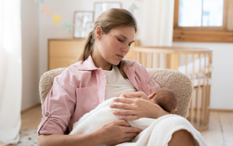 Kobieta siedząca z noworodkiem